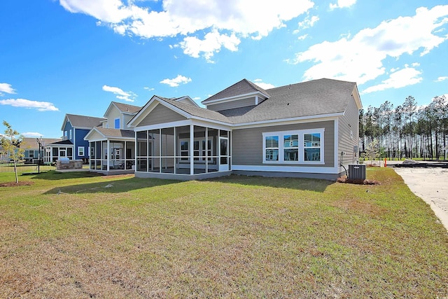 8723 Baton Rouge Ave NW, Calabash, NC 28467 - rear view of house featuring a sunroom, a lawn, and central AC