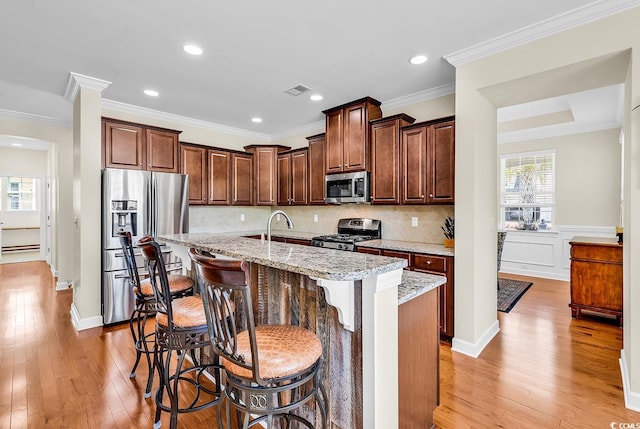 522 Heartland Ct, Murrells Inlet, SC 29576 - kitchen with crown molding, light wood-type flooring, appliances with stainless steel finishes, and an island with sink