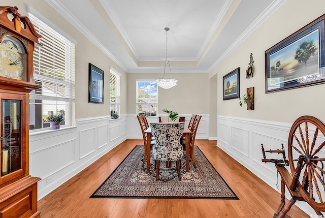 522 Heartland Ct, Murrells Inlet, SC 29576 - dining room featuring a raised ceiling, an inviting chandelier, ornamental molding, wainscoting, and light wood-style flooring