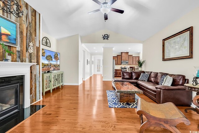 522 Heartland Ct, Murrells Inlet, SC 29576 - living room with a glass covered fireplace, baseboards, vaulted ceiling, light wood-type flooring, and a ceiling fan