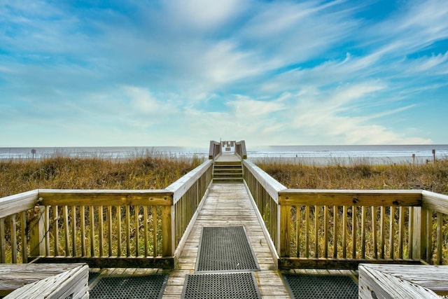 view of property's community featuring a water view and a beach view