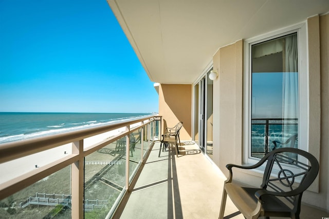 balcony featuring a water view and a beach view
