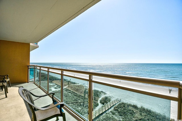 balcony featuring a view of the beach and a water view