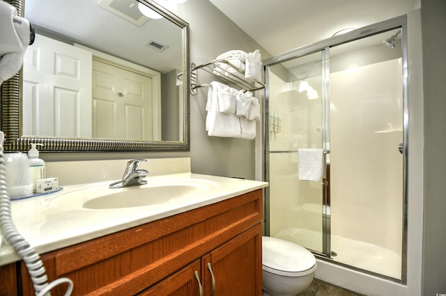 full bath with a shower stall, vanity, visible vents, and toilet