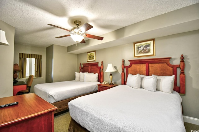 carpeted bedroom with a ceiling fan and a textured ceiling