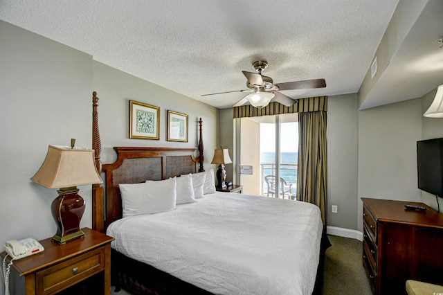 bedroom featuring dark colored carpet, baseboards, a textured ceiling, and ceiling fan
