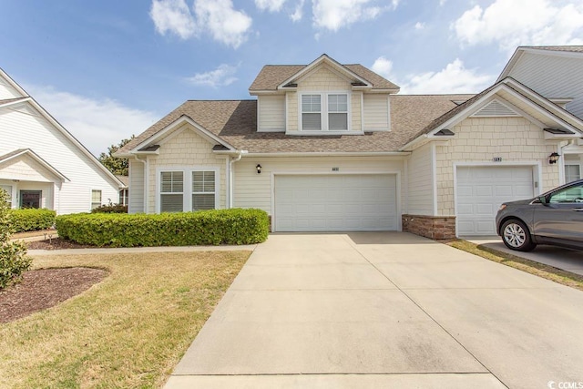 view of front of property with roof with shingles, driveway, and a front lawn
