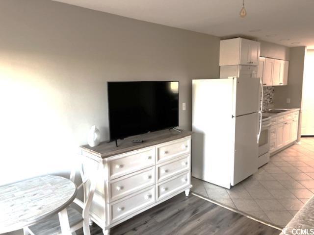 1100 Possum Trot Rd Unit G-216, North Myrtle Beach, SC 29582 - kitchen featuring freestanding refrigerator, white cabinetry, stove, and tile patterned floors