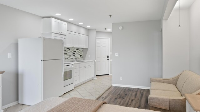 1100 Possum Trot Rd Unit G-216, North Myrtle Beach, SC 29582 - kitchen featuring white appliances, recessed lighting, decorative backsplash, white cabinets, and baseboards
