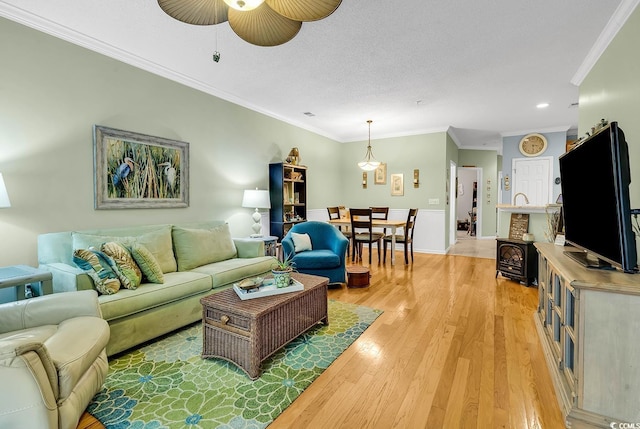 living area featuring light wood-style flooring, ornamental molding, ceiling fan, recessed lighting, and baseboards