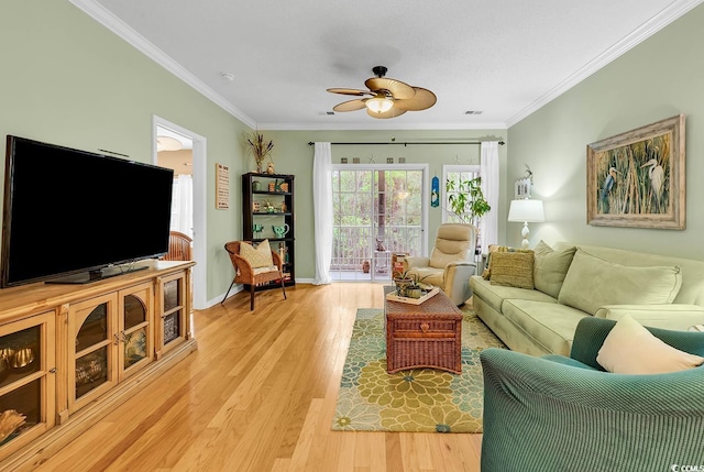 living room with a ceiling fan, ornamental molding, light wood-style flooring, and baseboards