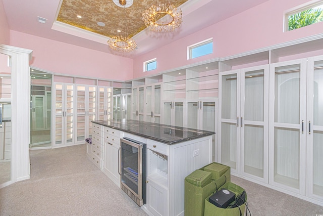 5208 Nightingale Dr, Myrtle Beach, SC 29577 - spacious closet featuring beverage cooler, a chandelier, light colored carpet, a tray ceiling, and a towering ceiling