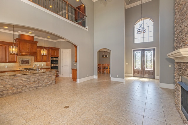 5208 Nightingale Dr, Myrtle Beach, SC 29577 - entrance foyer with a stone fireplace, arched walkways, a high ceiling, crown molding, and french doors