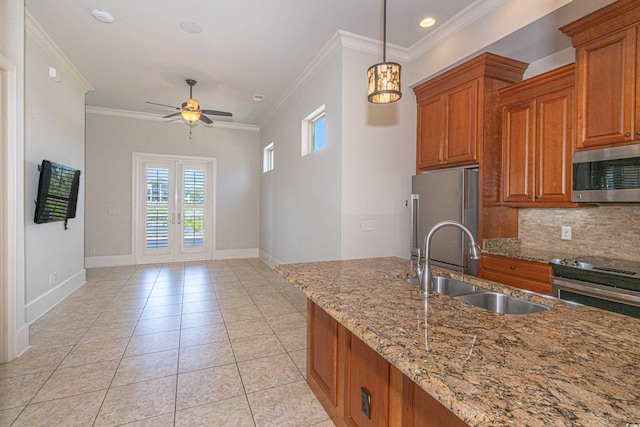 5208 Nightingale Dr, Myrtle Beach, SC 29577 - kitchen featuring appliances with stainless steel finishes, crown molding, brown cabinets, a sink, and a ceiling fan