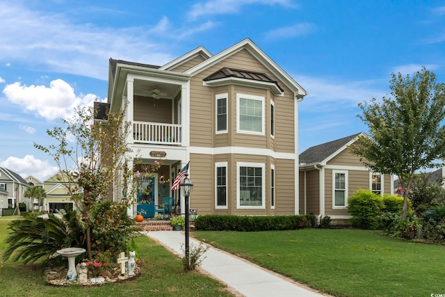 view of front facade featuring a front lawn, a ceiling fan, and a balcony