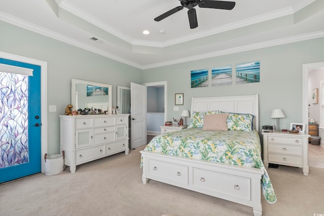 bedroom with crown molding, visible vents, light carpet, and a tray ceiling