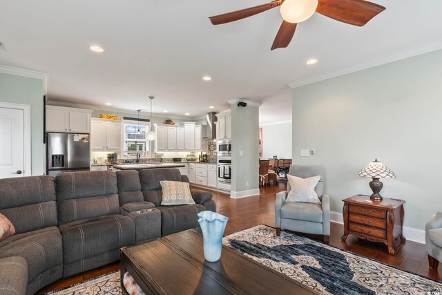living area featuring dark wood-style floors, recessed lighting, and crown molding
