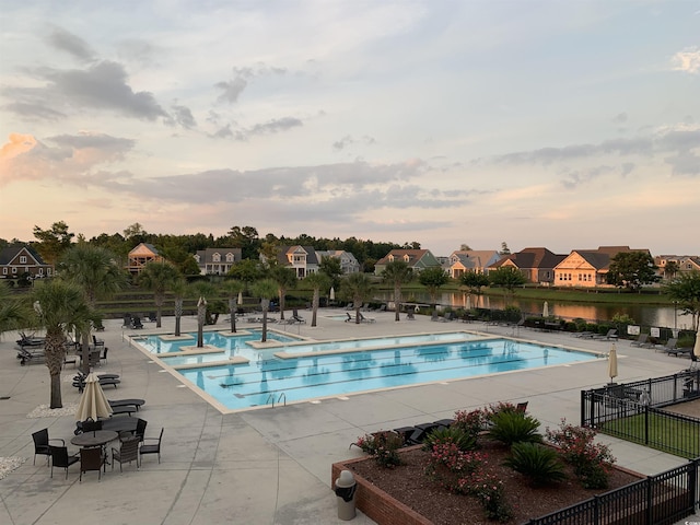 712 Crystal Water Way, Myrtle Beach, SC 29579 - pool at dusk featuring a patio, a community pool, and a residential view