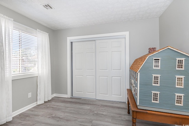 3015 Old Bryan Dr Unit 10-7, Myrtle Beach, SC 29577 - unfurnished bedroom featuring a textured ceiling, wood finished floors, and baseboards