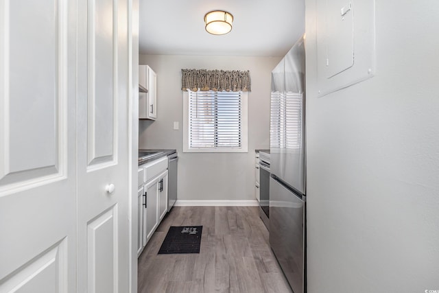 3015 Old Bryan Dr Unit 10-7, Myrtle Beach, SC 29577 - kitchen with baseboards, electric panel, white cabinets, appliances with stainless steel finishes, and wood finished floors