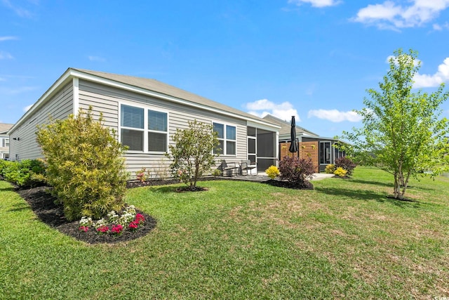 rear view of house with a yard and a sunroom