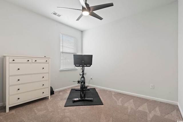 exercise area featuring ceiling fan, light carpet, and baseboards