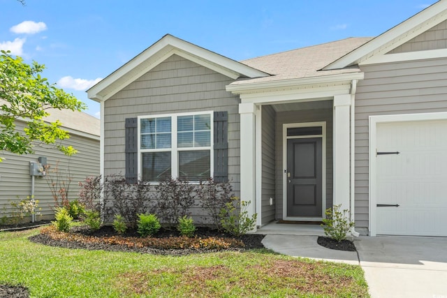 property entrance with a garage and concrete driveway
