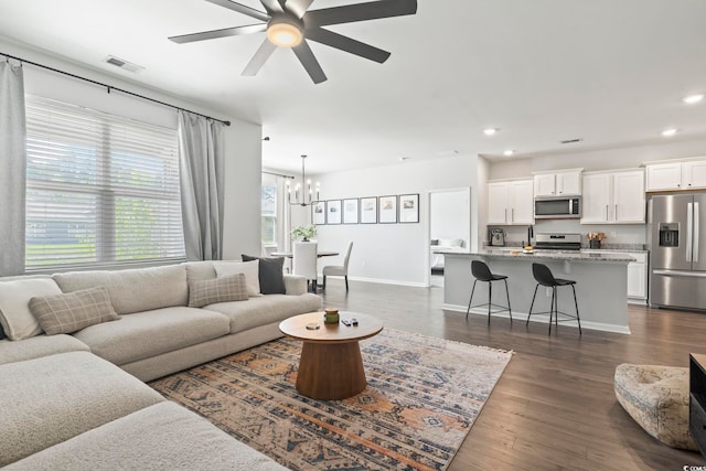 living room with a chandelier, recessed lighting, ceiling fan, baseboards, and dark wood-style floors