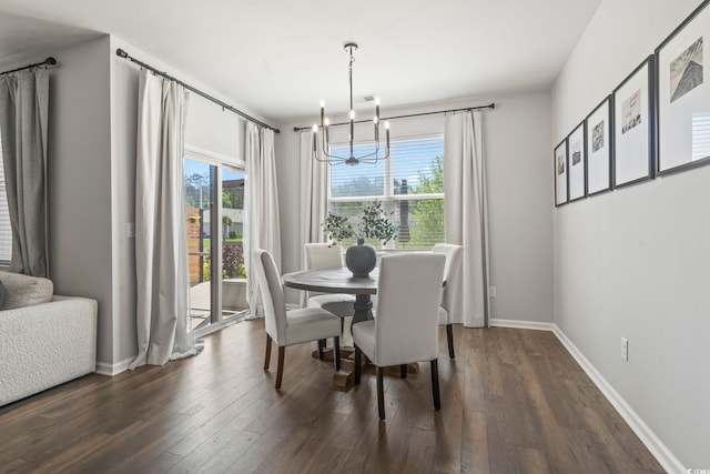 dining area featuring a chandelier, dark wood-style floors, and baseboards