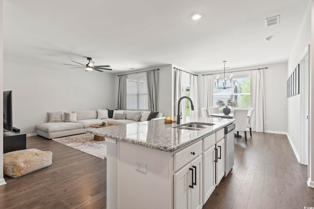 kitchen with a sink, stainless steel dishwasher, a kitchen island with sink, white cabinets, and dark wood-style flooring