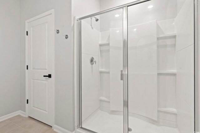bathroom featuring a shower stall, baseboards, and tile patterned floors