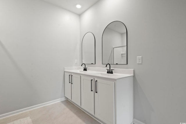 full bath with baseboards, double vanity, tile patterned flooring, and recessed lighting