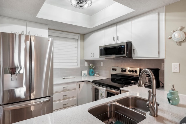 223 Maison Dr Unit F-4, Myrtle Beach, SC 29572 - kitchen featuring light stone countertops, white cabinetry, appliances with stainless steel finishes, a sink, and decorative backsplash