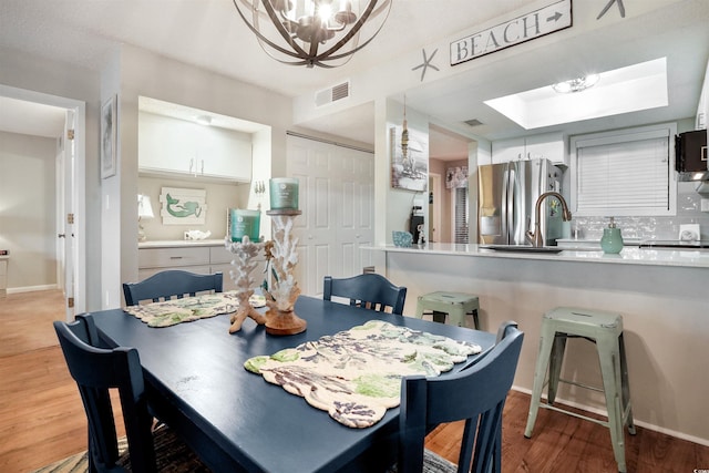 223 Maison Dr Unit F-4, Myrtle Beach, SC 29572 - dining area featuring a notable chandelier, baseboards, visible vents, a skylight, and wood finished floors