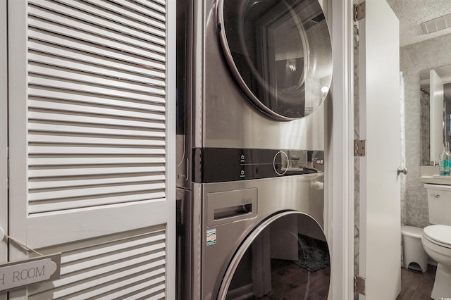 223 Maison Dr Unit F-4, Myrtle Beach, SC 29572 - laundry area with laundry area, a textured ceiling, visible vents, wood finished floors, and stacked washing maching and dryer