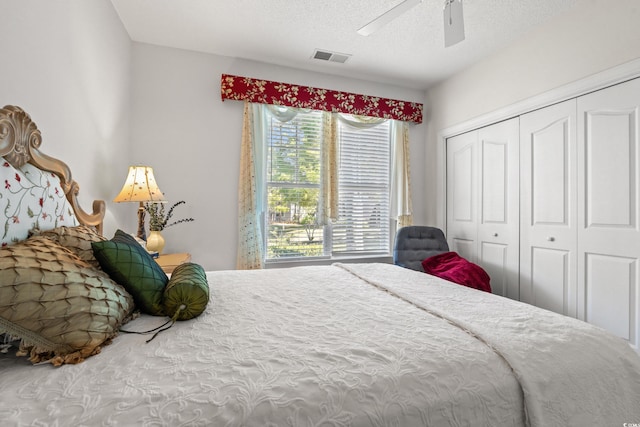 bedroom featuring a ceiling fan, a closet, a textured ceiling, and visible vents