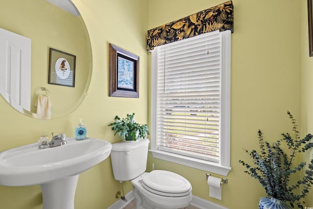 bathroom featuring a sink, baseboards, and toilet