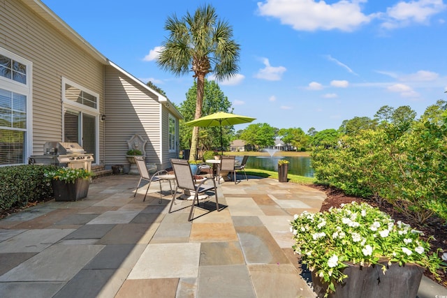 view of patio / terrace featuring area for grilling, a water view, and outdoor dining space