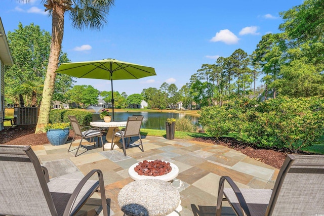 view of patio / terrace with a water view, a fire pit, and outdoor dining space