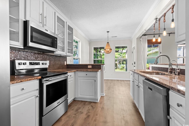 405 Emerson Dr, Myrtle Beach, SC 29579 - kitchen with a peninsula, ornamental molding, appliances with stainless steel finishes, a sink, and decorative backsplash