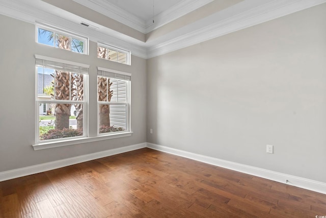 unfurnished room with wood finished floors, baseboards, and crown molding