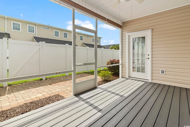 unfurnished sunroom featuring ceiling fan