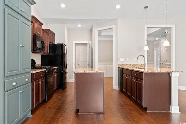 kitchen featuring black appliances, a sink, a peninsula, a center island, and light stone countertops