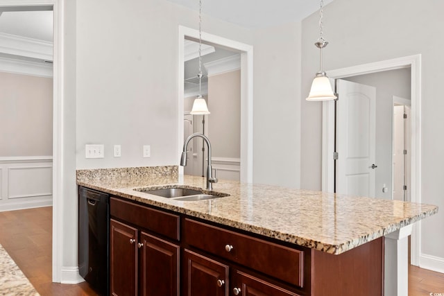 kitchen with a sink, black dishwasher, wood finished floors, crown molding, and light stone counters