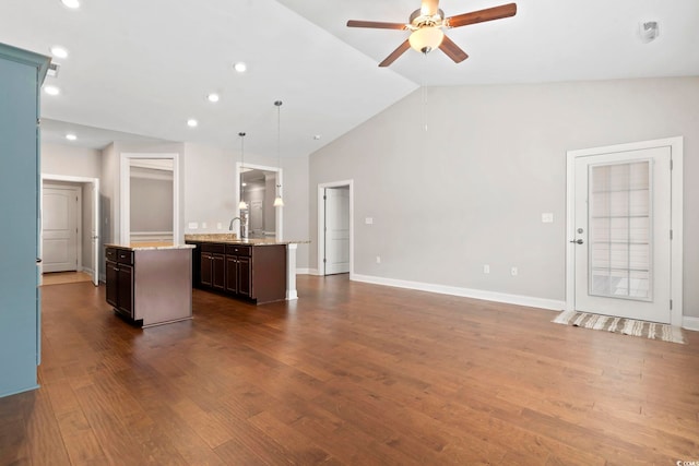 unfurnished living room with ceiling fan, lofted ceiling, a sink, dark wood finished floors, and recessed lighting