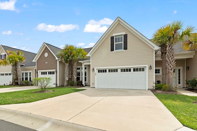 traditional-style house with concrete driveway, an attached garage, and a front lawn