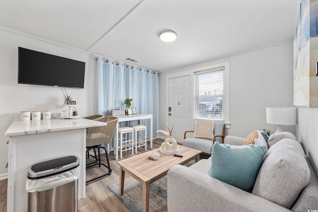 living area featuring visible vents and wood finished floors