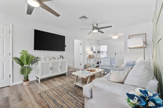 living room featuring ceiling fan, light wood-type flooring, and visible vents
