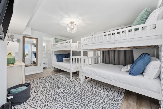 bedroom featuring an inviting chandelier and wood finished floors
