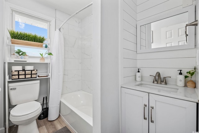 bathroom with vanity, toilet, wood finished floors, and shower / tub combo with curtain